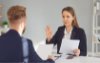 Woman talking to a man with her hand up to indicate stop or no