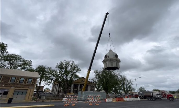 Crane lifting up final piece of a courthouse