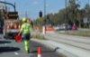 Road worker carrying traffic cones