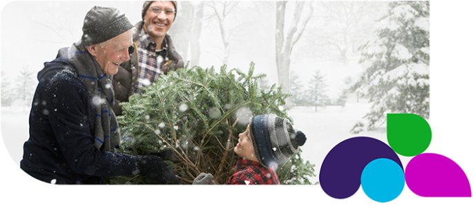 People holding up a christmas tree in the snow