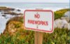 "No Fireworks" sign on beach cliff